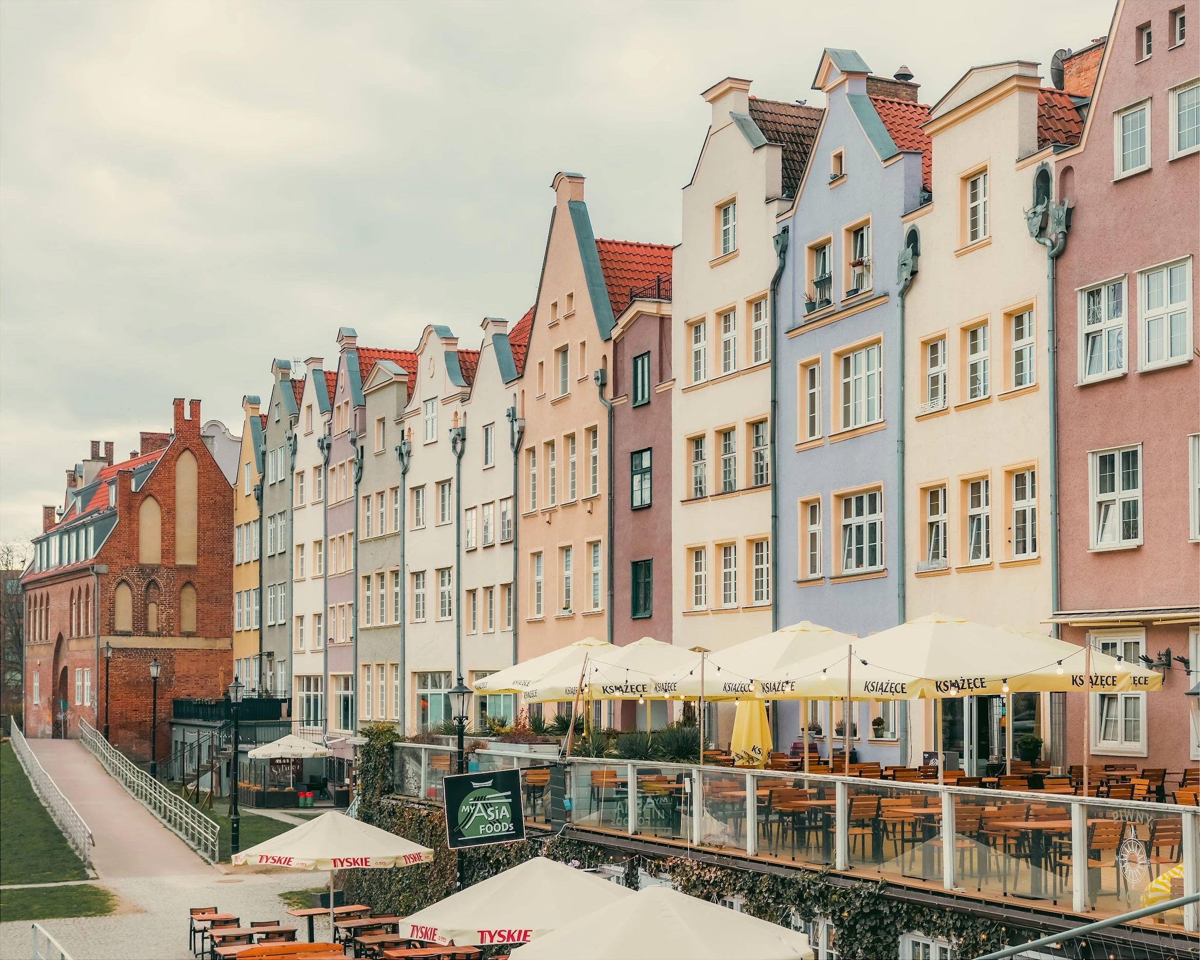 Pastel-coloured gabled houses and café terraces along Gdańsk's waterfront.