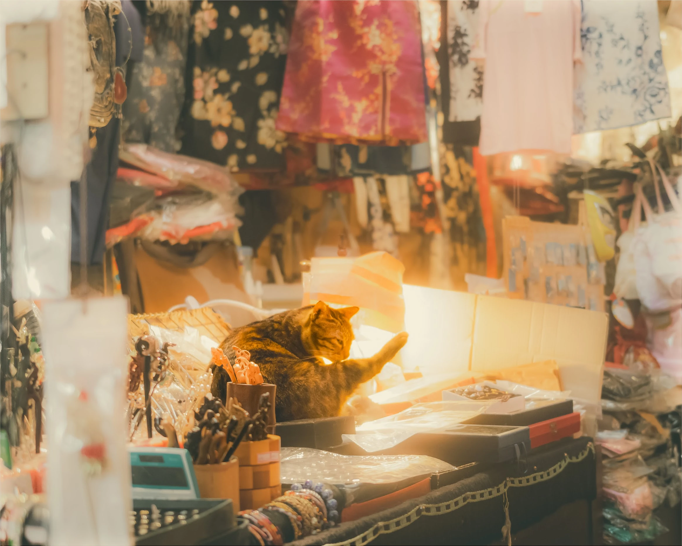Sunlight falling across souvenirs, fabrics and small objects in a Taiwanese shop.